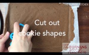 Cutting out gingerbread man shapes with cookie cutter on cookie dough