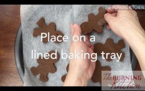Placing gingerbread man dough pieces on baking paper on baking tray