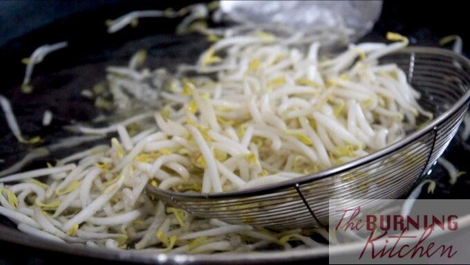 Removing the beansprouts from the wok after blanching